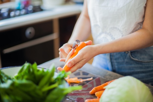 Close-up of hands peeling carrot