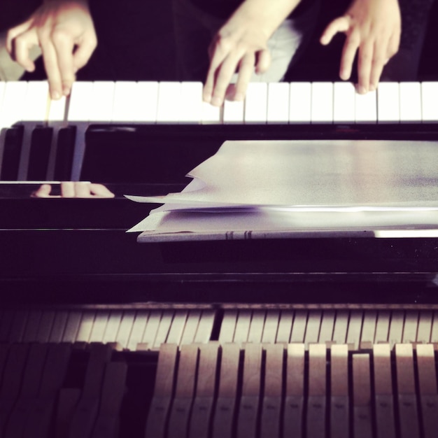 Foto close-up di mani che suonano il pianoforte