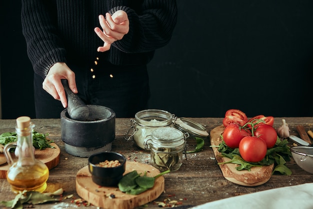 Primo piano delle mani che preparano il cibo in cucina