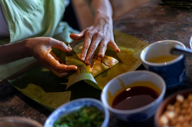 Close up of hands preparing hallaca or tamale Traditional food concept