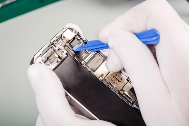 Close up hands of a service worker repairing modern smarphone