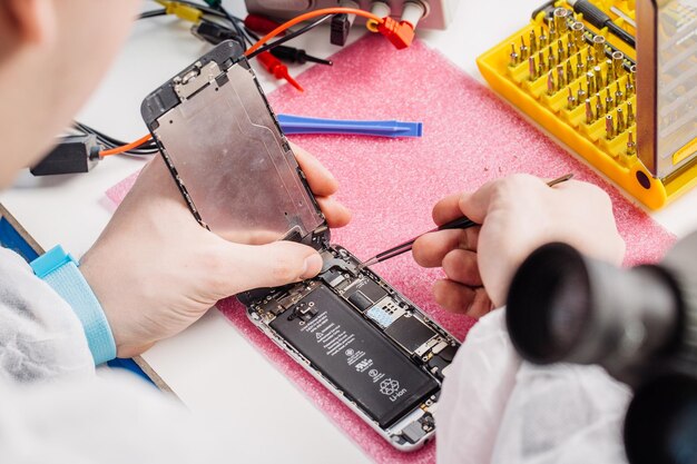 Close up hands of a service worker repairing modern smarphone