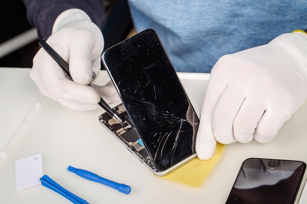 Close up hands of a service worker repairing modern smarphone