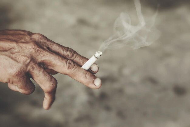 Photo close-up of hands smoking cigarette