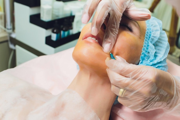 Close up of a hands threading beautiful womans upper lip