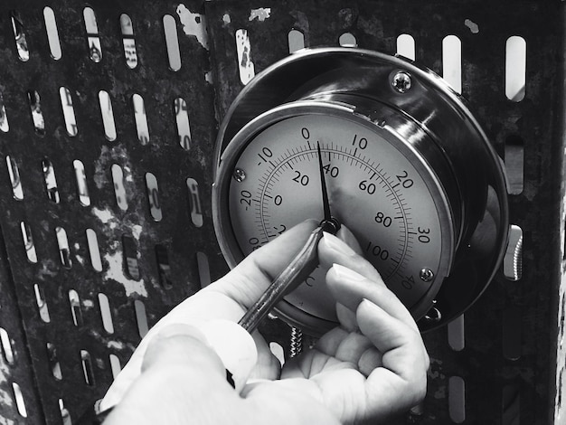 Photo close-up of hands touching gauge