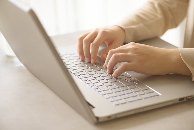 Close-up of hands typing on laptop keyboard at the office. Copy space. Worker, business, remote work, always connect, online banking concept. Soft focus