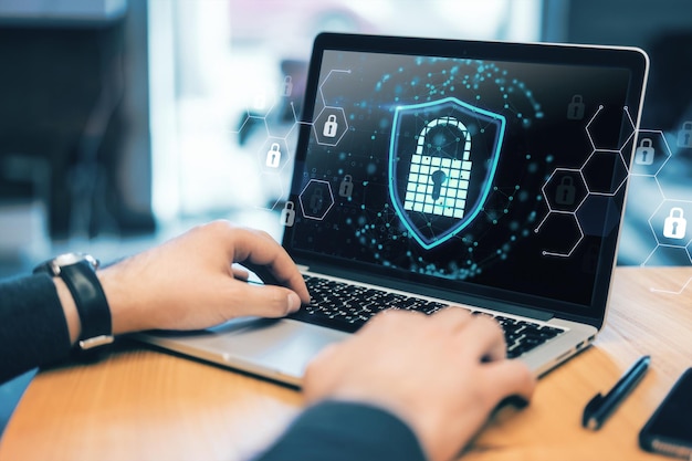 Close up on hands typing on laptop with a cyber security lock symbol Data protection concept