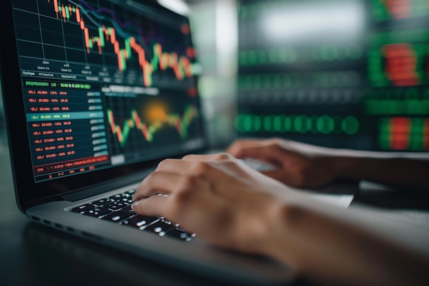 Photo close up of hands typing on laptop with stock graphs on the screen financial investment concept