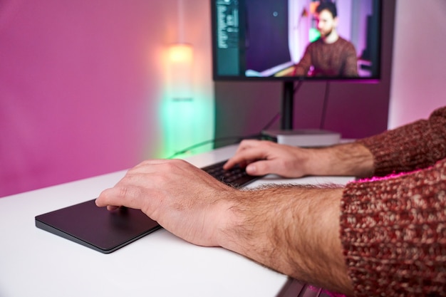 Close-up of hands typing in room of lights and colors