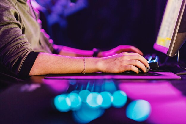 Close up of hands using keyboard and mouse for game at gaming room