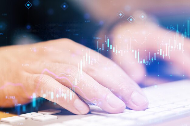 Close up of hands using keyboard with glowing forex chart on blurry background Fintech digital transformation and finance concept Double exposure