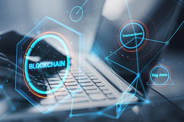 Close up of hands using laptop keyboard with creative polygonal blockchain hologram on blurry background Technology crypto financial data and fintech concept Double exposure