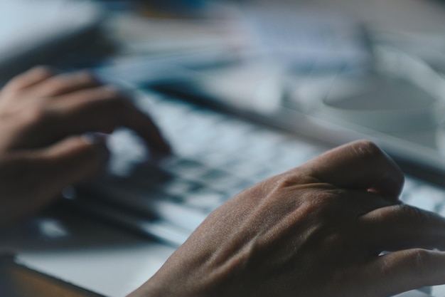 Photo close-up of hands using laptop