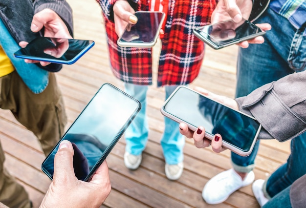 Foto chiuda in su delle mani utilizzando i telefoni cellulari intelligenti