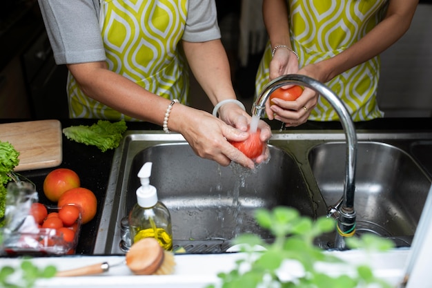 Photo close up hands washing tomatoes