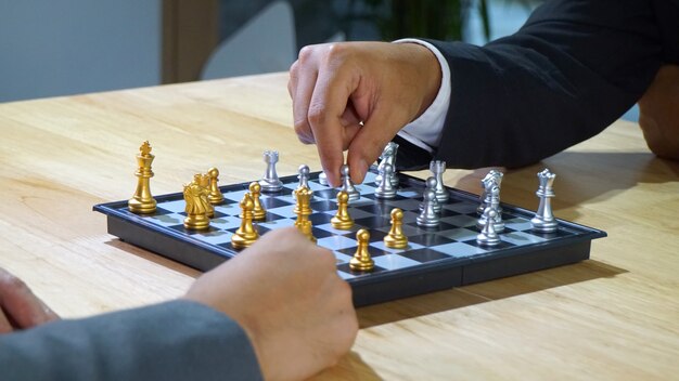 Close-Up Of hands with Chess Board On Table