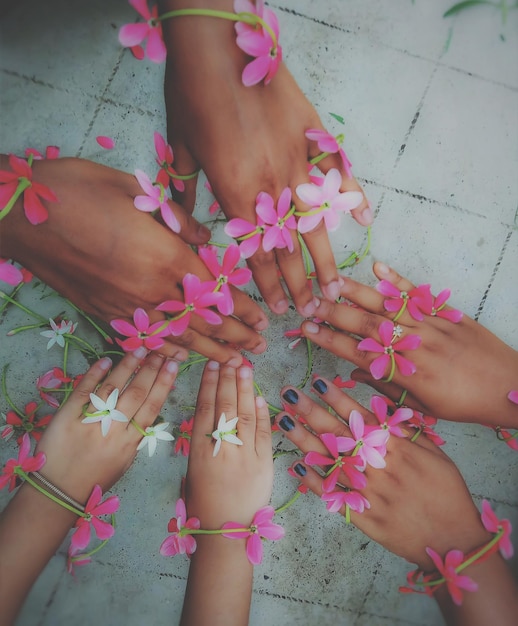 Photo close-up of hands with flowers over floor