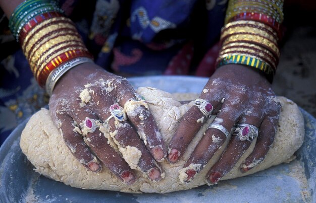 Photo close-up of hands with rings preparing dough