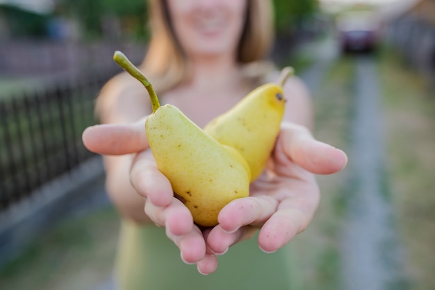 close up of hands - woman holding a yellow pear - thanksgiving - gardening