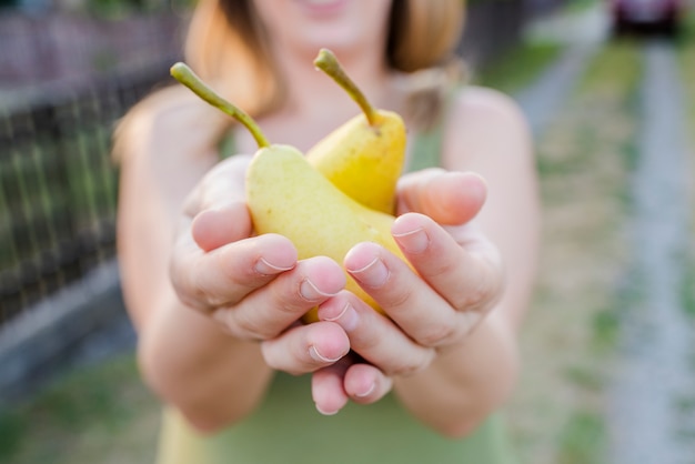 close up of hands - woman holding a yellow pear - thanksgiving - gardening