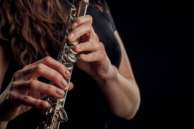 close-up of the hands of a woman playing the flute. musical concept.
