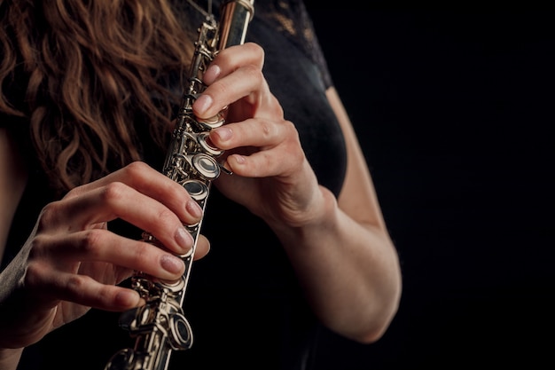 Primo piano delle mani di una donna che suona il flauto. concetto musicale.