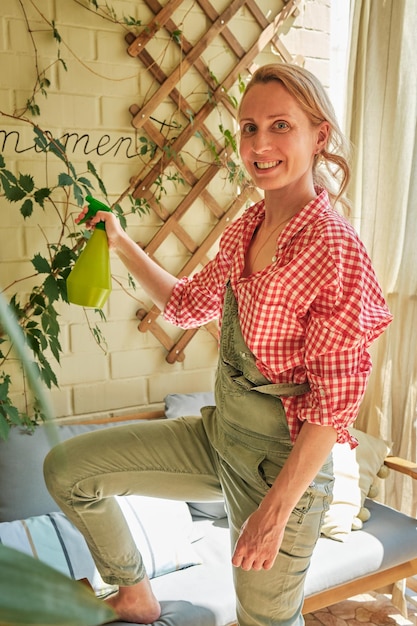 close up hands woman takes care of plants on the balcony in her apartment home gardening