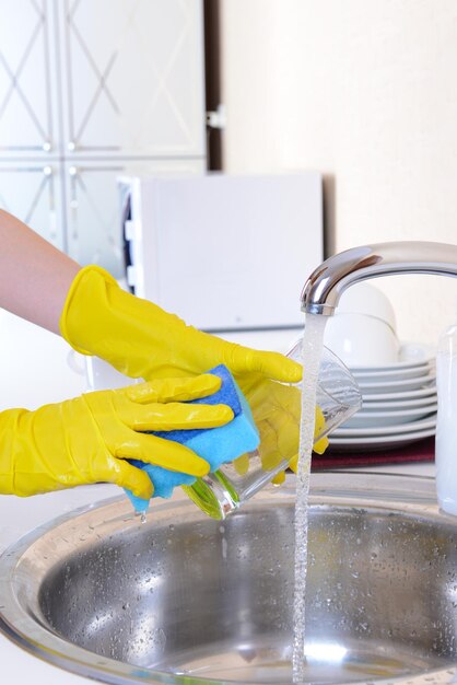 Close up hands of woman washing dishes in kitchen