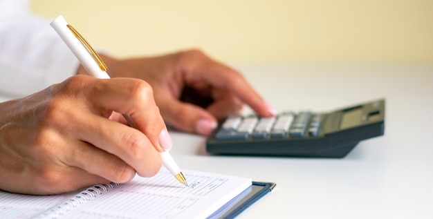 Close-up of the hands of a woman writing in a notebook