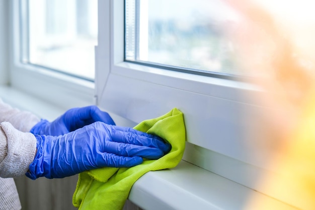 Close-up of hands working on window at home