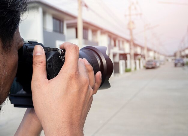 Close up hands of Young Asian photographer taking pictures of housing estates