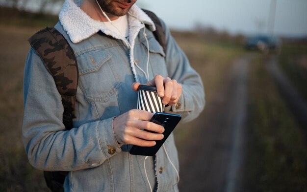 Close up of hands of young modern guy with backpack