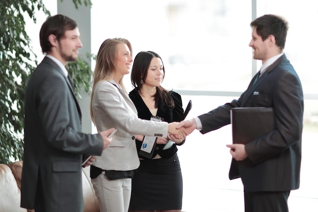 Close up handshake business woman with businessman in modern business center