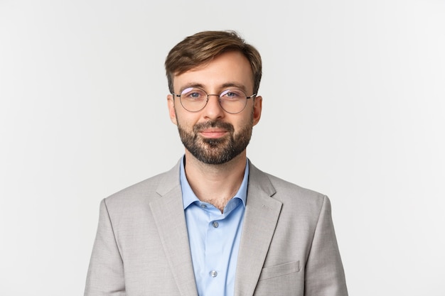 Close up of handsome bearded businessman in gray suit and glasses