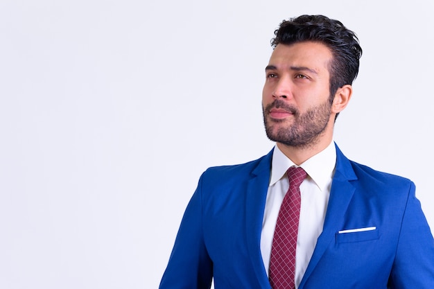 Close up of handsome bearded Turkish businessman wearing suit isolated