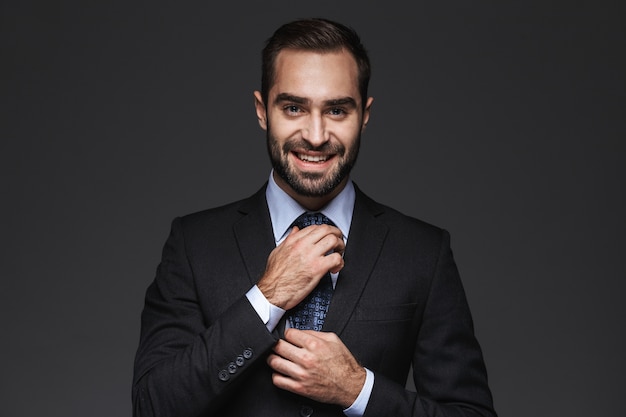 Close up of a handsome young smiling business man wearing suit standing isolated