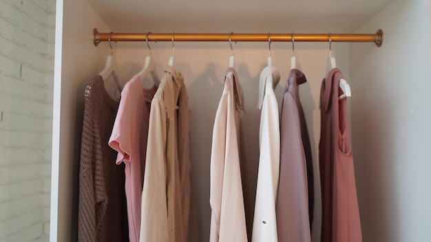 Close up of hangers with different clothes in wardrobe