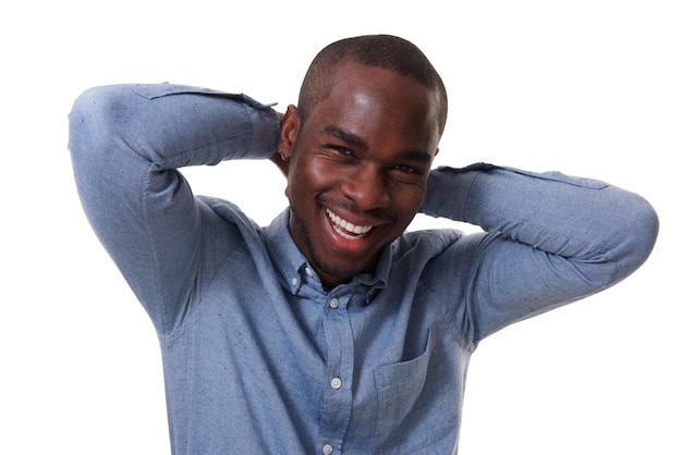 Close up happy african american man laughing with hands behind head against white background