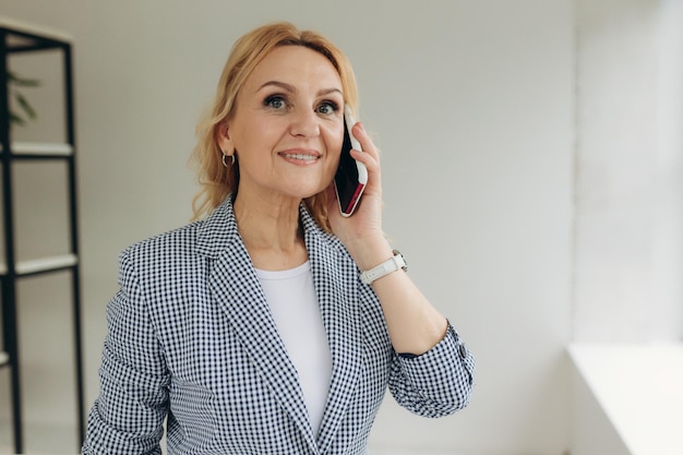 Close up of happy aged businesswoman in glasses talk on smartphone consulting client online smiling senior woman speak on cellphone use wireless connection Technology concept