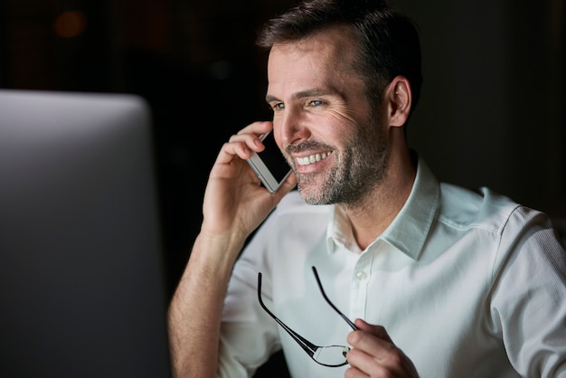 Close up of happy businessman talking by mobile phone