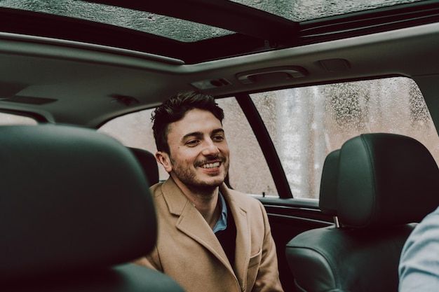 Photo close-up of happy businessman traveling in car