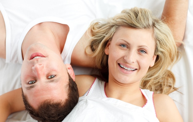 Photo close-up of happy couple resting in bed