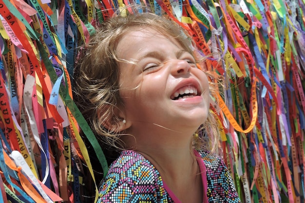 close-up of happy girl against multi colored ribbons