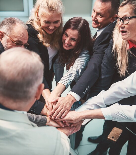 Close up. happy group of employees making a stack of hands