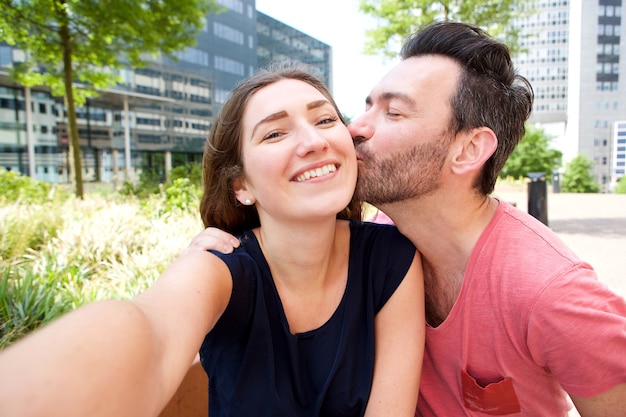 Close up happy romantic couple taking selfie outside in city