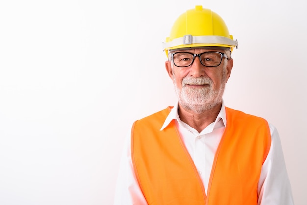 Close up of happy senior bearded man construction worker smiling while wearing eyeglasses on white