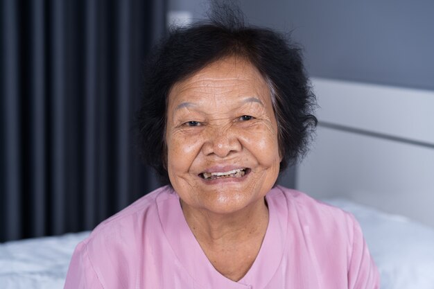 Photo close up of happy smiling senior woman face in bedroom