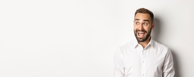 Close-up of happy and surprised man looking left with excitement white background