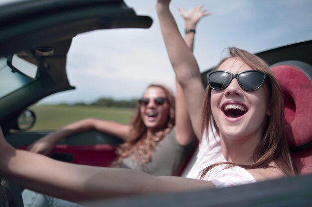 コンバーチブルを運転している幸せな女性をクローズアップ